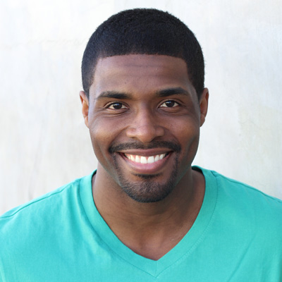 An elderly couple posing for a photo with smiles, embracing each other.